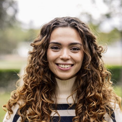 Portrait of young caucasian woman with blonde curly hair smiling and looking at camera Portrait of young caucasian woman with blonde curly hair smiling and looking at camera